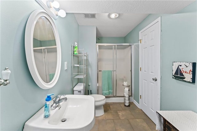 bathroom with sink, an enclosed shower, and toilet