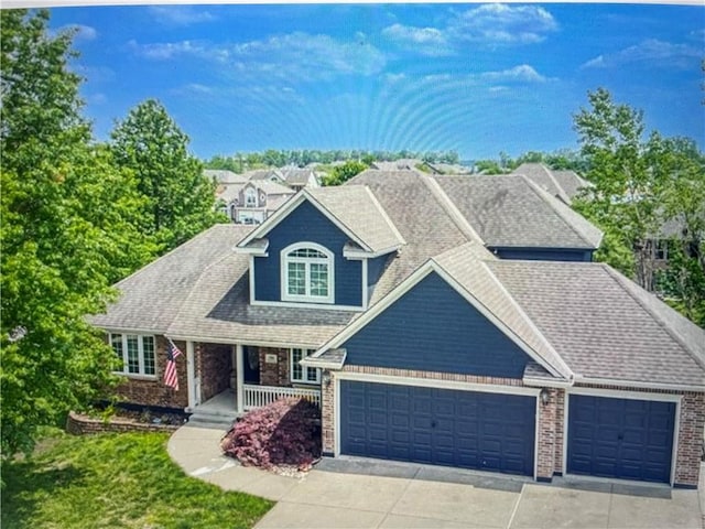 view of front of property with a porch, a garage, a shingled roof, brick siding, and driveway