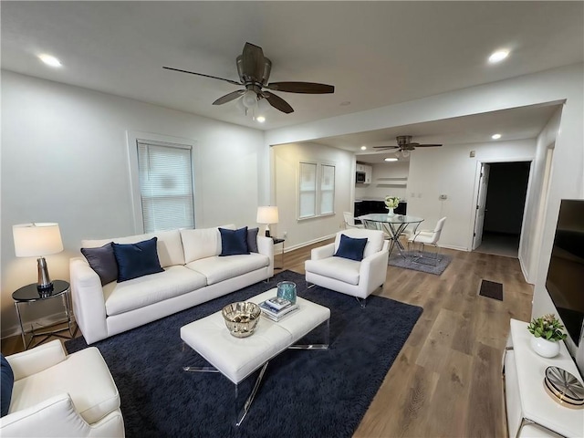 living room featuring wood-type flooring and ceiling fan