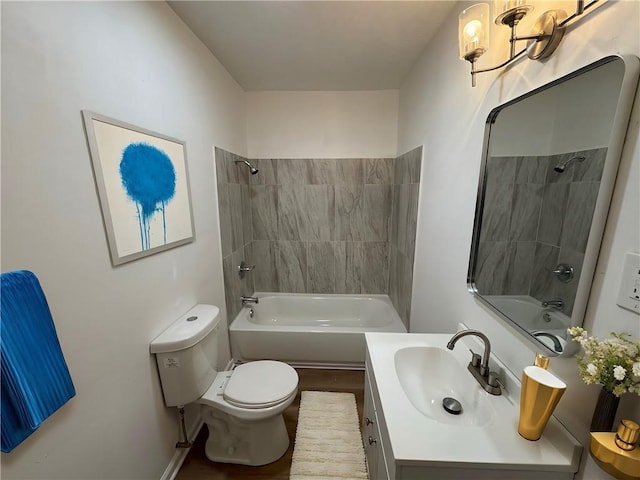 full bathroom featuring tiled shower / bath, vanity, and toilet