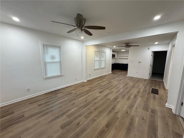 unfurnished living room featuring dark hardwood / wood-style floors and ceiling fan