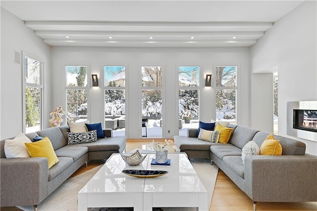 living room with beam ceiling and light hardwood / wood-style flooring