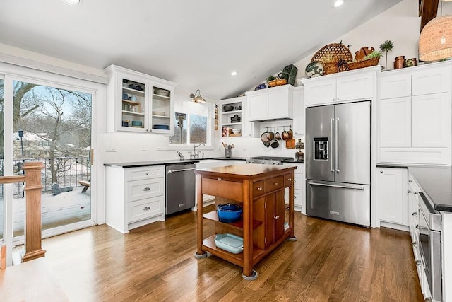 kitchen featuring white cabinets, appliances with stainless steel finishes, open shelves, dark countertops, and glass insert cabinets