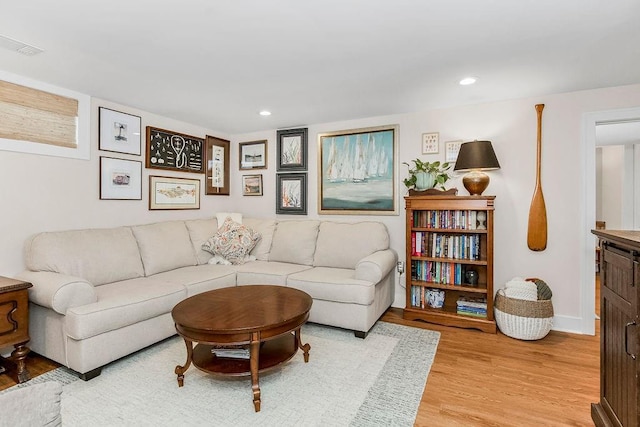 living room featuring recessed lighting, baseboards, visible vents, and light wood finished floors