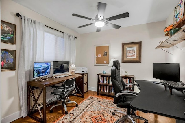 office featuring baseboards, a ceiling fan, and wood finished floors