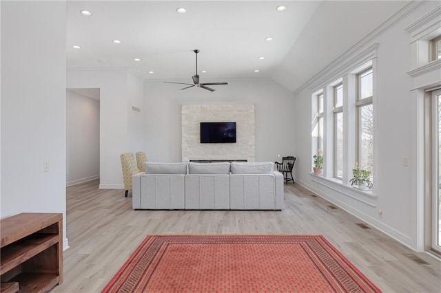 living room featuring vaulted ceiling, ornamental molding, ceiling fan, and light hardwood / wood-style flooring