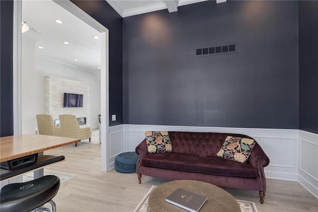 living room featuring ornamental molding and light hardwood / wood-style floors