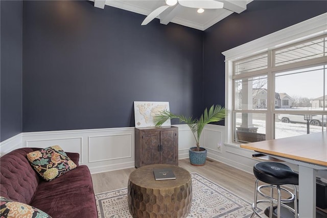 home office featuring beam ceiling, ornamental molding, light hardwood / wood-style floors, and ceiling fan