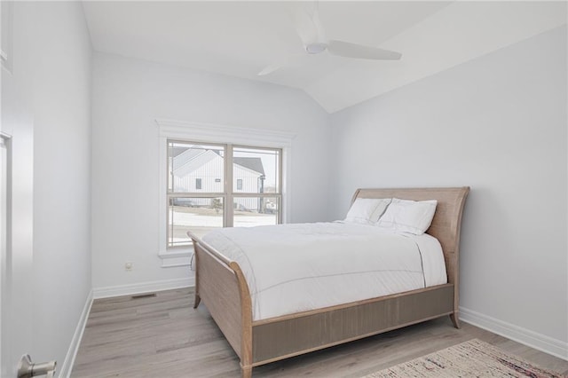 bedroom with vaulted ceiling, ceiling fan, and light wood-type flooring