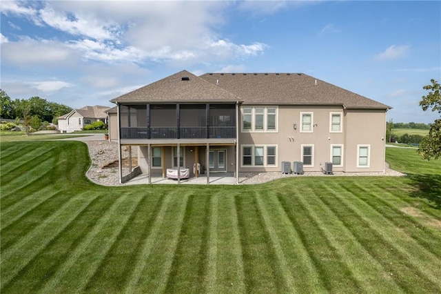 rear view of property with a yard, a patio area, a sunroom, and central air condition unit