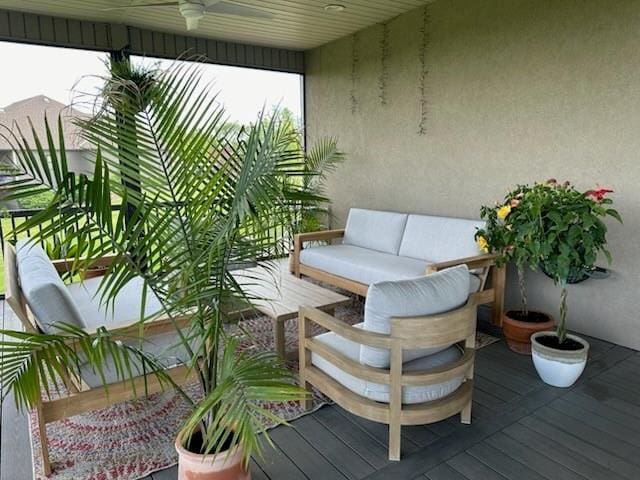 wooden balcony featuring a wooden deck, an outdoor living space, and ceiling fan