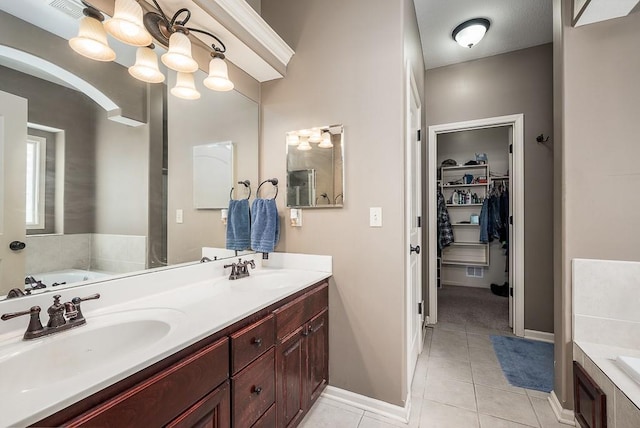 bathroom featuring a relaxing tiled tub, vanity, an inviting chandelier, and tile patterned flooring