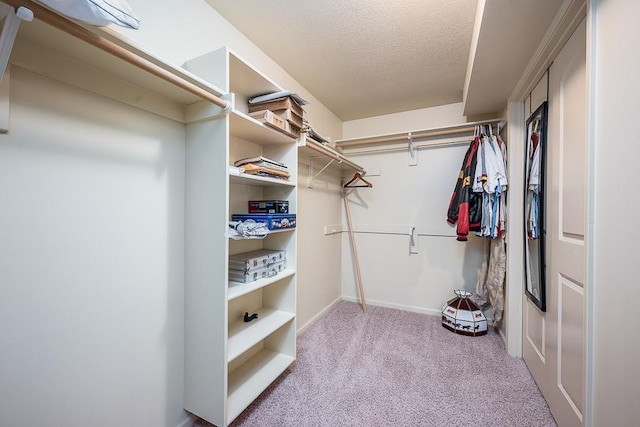 walk in closet featuring light colored carpet