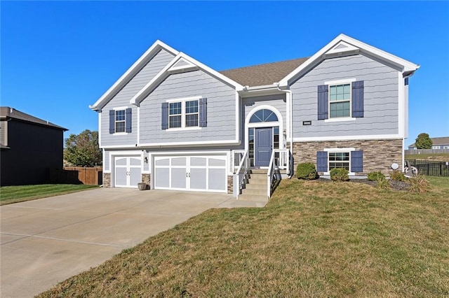 raised ranch featuring a front yard and a garage