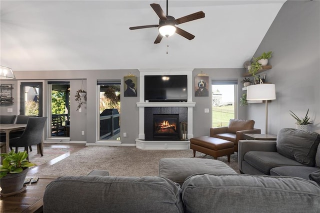 living room with ceiling fan, lofted ceiling, and a fireplace