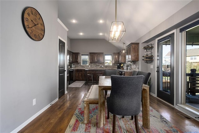 dining area featuring lofted ceiling and dark hardwood / wood-style floors