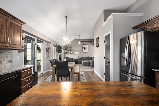 kitchen with light stone counters, stainless steel refrigerator with ice dispenser, black dishwasher, ceiling fan, and dark brown cabinets