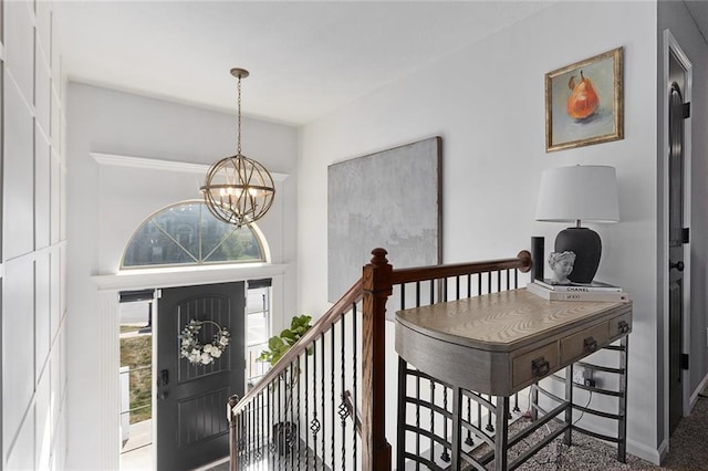 entrance foyer with an inviting chandelier and carpet