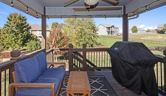 wooden terrace featuring ceiling fan, a lawn, and area for grilling