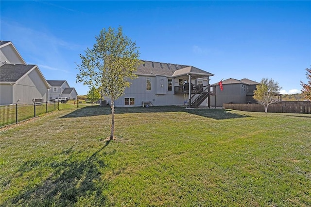 rear view of house featuring a deck and a yard