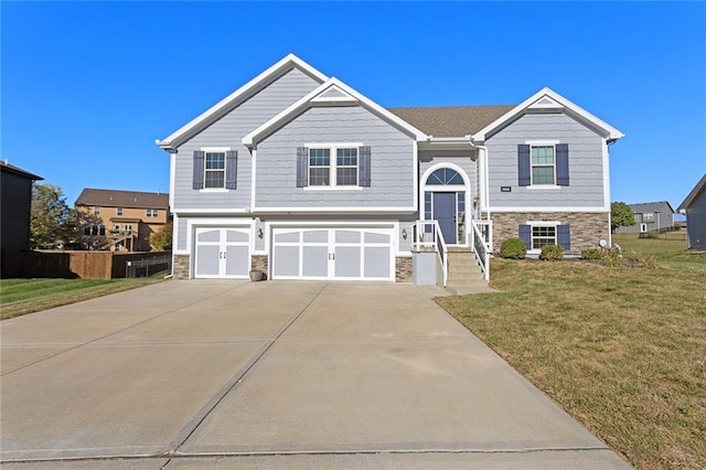 split foyer home featuring a front lawn and a garage