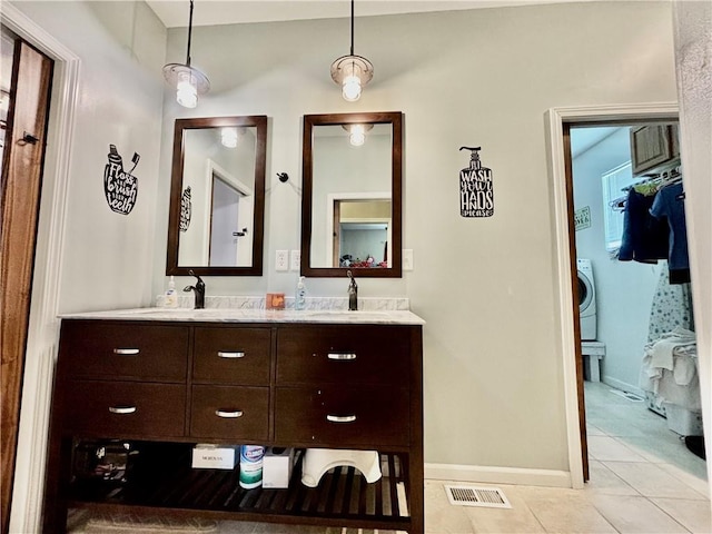 bathroom featuring washer / clothes dryer, vanity, and tile patterned flooring