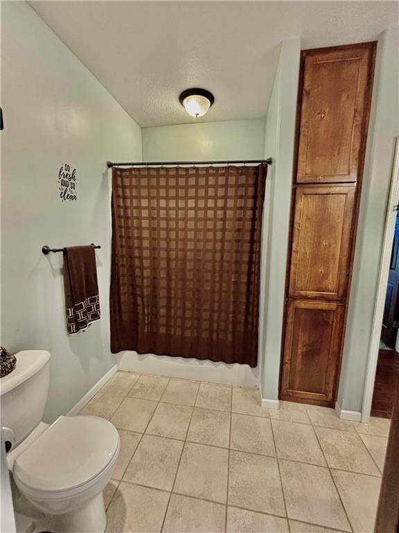 bathroom with tile patterned flooring, shower / bath combination with curtain, and toilet