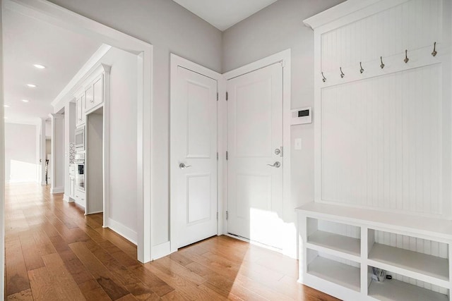 mudroom with recessed lighting, baseboards, and wood-type flooring