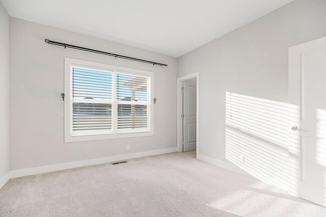 carpeted empty room with visible vents and baseboards