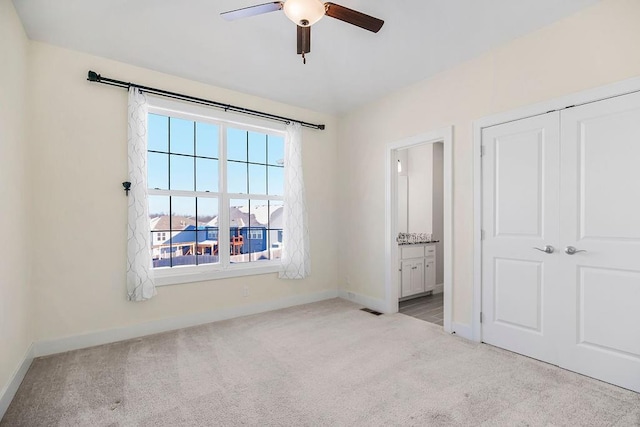 unfurnished bedroom featuring visible vents, carpet, baseboards, and ensuite bathroom