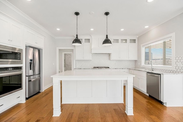 kitchen with decorative backsplash, stainless steel appliances, white cabinets, light countertops, and glass insert cabinets