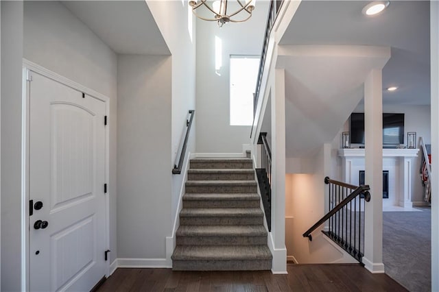 stairway with a chandelier and wood-type flooring