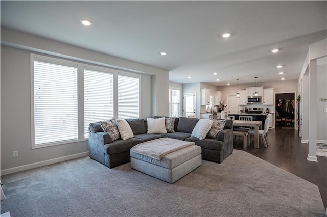 living room featuring dark wood-type flooring and a healthy amount of sunlight