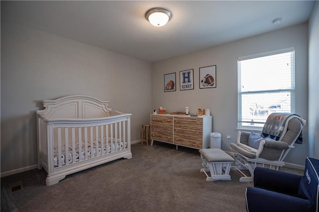 bedroom featuring dark colored carpet and a nursery area