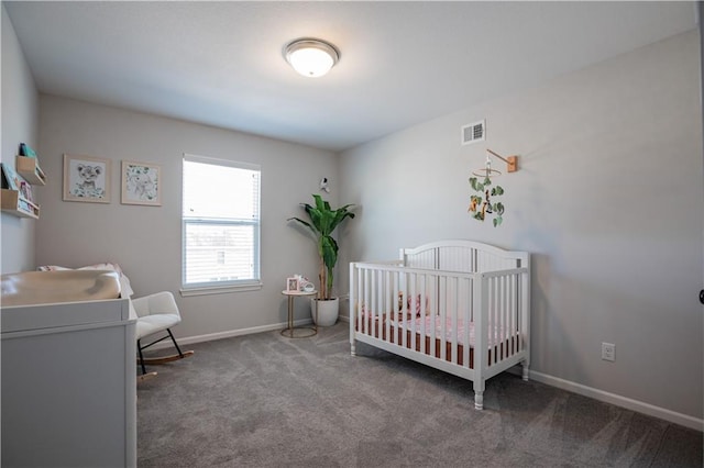 carpeted bedroom featuring a nursery area