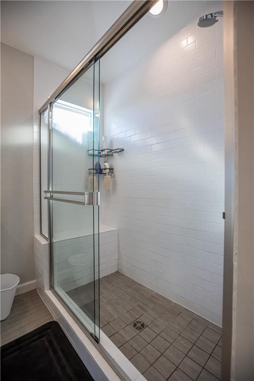 bathroom with hardwood / wood-style floors and a shower with door