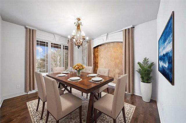 dining area with baseboards, dark wood-type flooring, and a notable chandelier