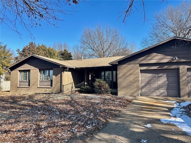 single story home with a garage, driveway, and brick siding