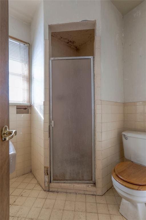 bathroom with walk in shower, tile walls, and toilet