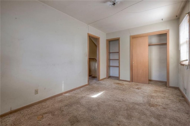 unfurnished bedroom featuring light carpet and a closet