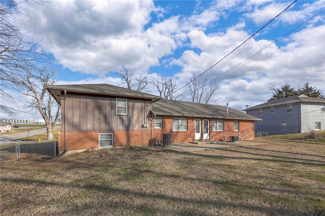 back of property with central air condition unit and a yard