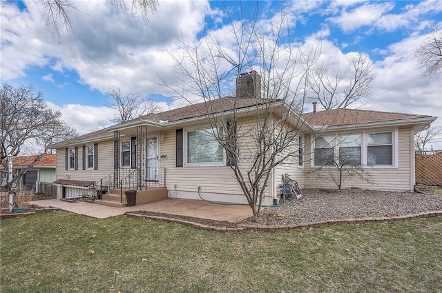 ranch-style home with a chimney, fence, a front lawn, and a patio