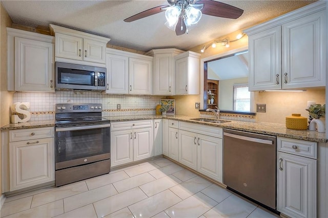 kitchen with tasteful backsplash, white cabinetry, stainless steel appliances, and a sink