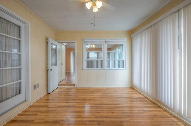 unfurnished sunroom with ceiling fan and visible vents