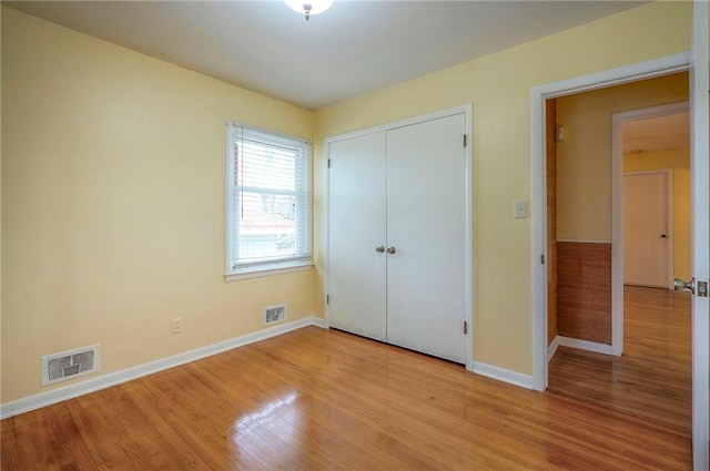 unfurnished bedroom with light wood-style floors, a closet, visible vents, and baseboards