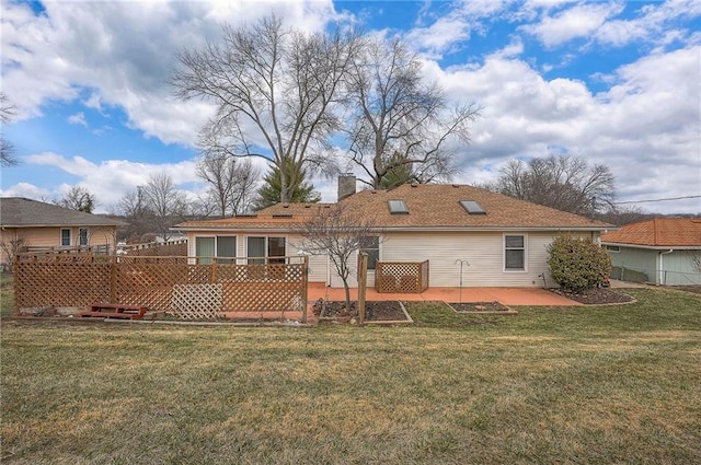 back of house featuring a patio area, a yard, a chimney, and a wooden deck