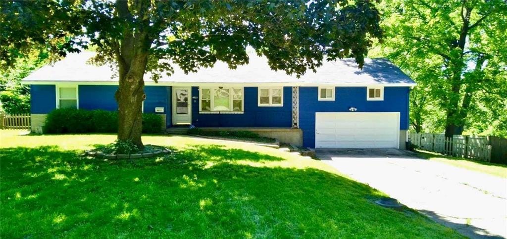 view of front of property featuring a garage and a front lawn