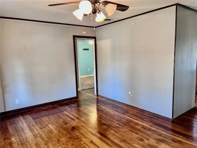 empty room featuring ceiling fan, ornamental molding, and dark wood-type flooring