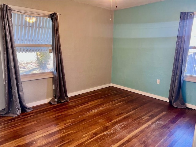 unfurnished room with dark wood-type flooring