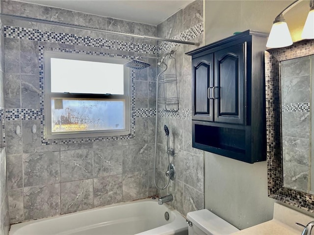 full bathroom with vanity, tiled shower / bath combo, and toilet